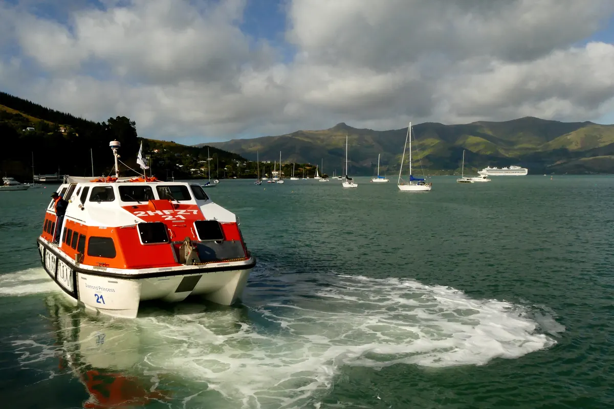 Cruise ship tender boat carrying passengers ashore across Akaroa Harbour on a port day